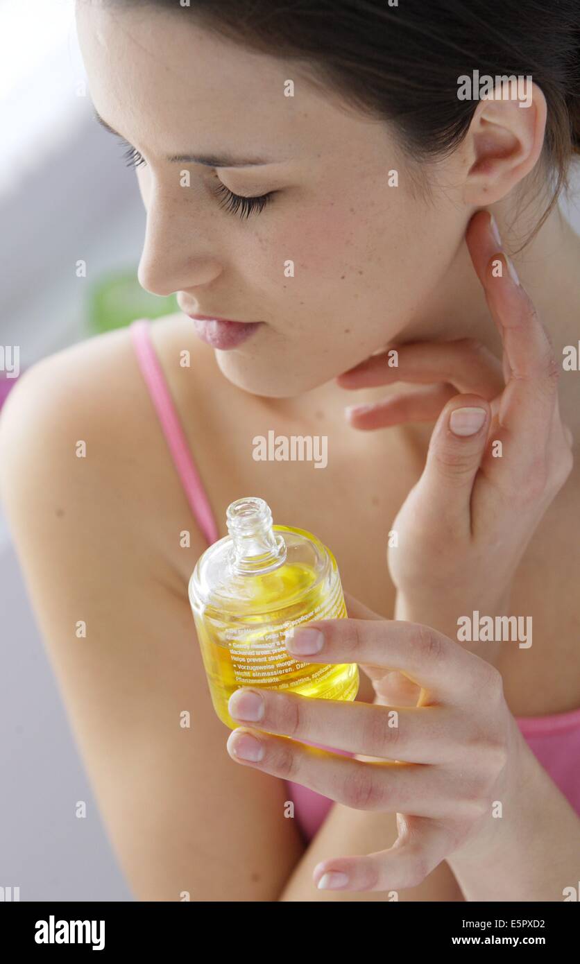 Frauen, die duftenden Öl am Hals auftragen. Stockfoto