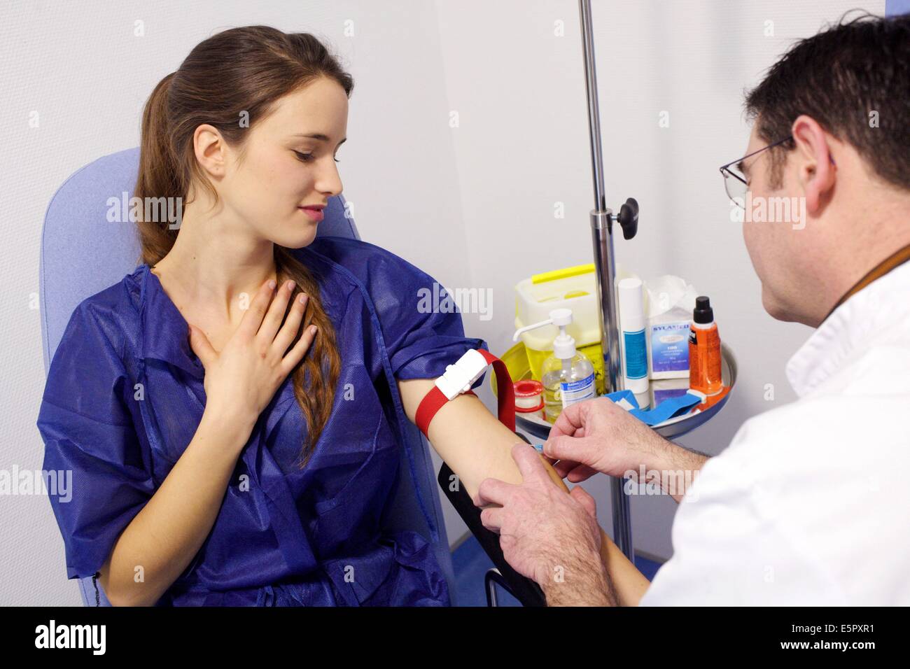 Vorbereitung vor dem MRT (Magnet-Resonanz-Tomographie) mit Kontrast, Krankenschwester Einstellung einen Tropf am Arm des Patienten für die Injektion Stockfoto