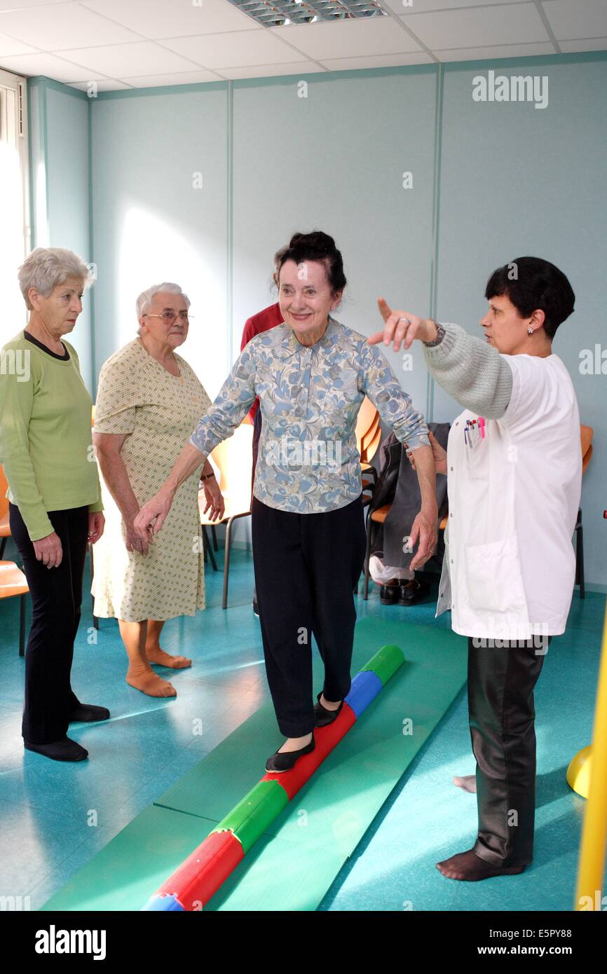 Ältere Frauen üben körperliche Übungen in einem Workshop namens Balance und Sturzprophylaxe, Patienten erfahren Sie, wie Sie teilnehmen können Stockfoto