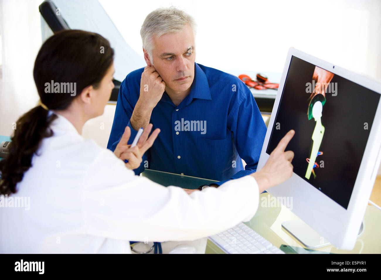 Arzt diskutieren Hüftgelenkersatz Röntgen mit einem Patienten. Stockfoto