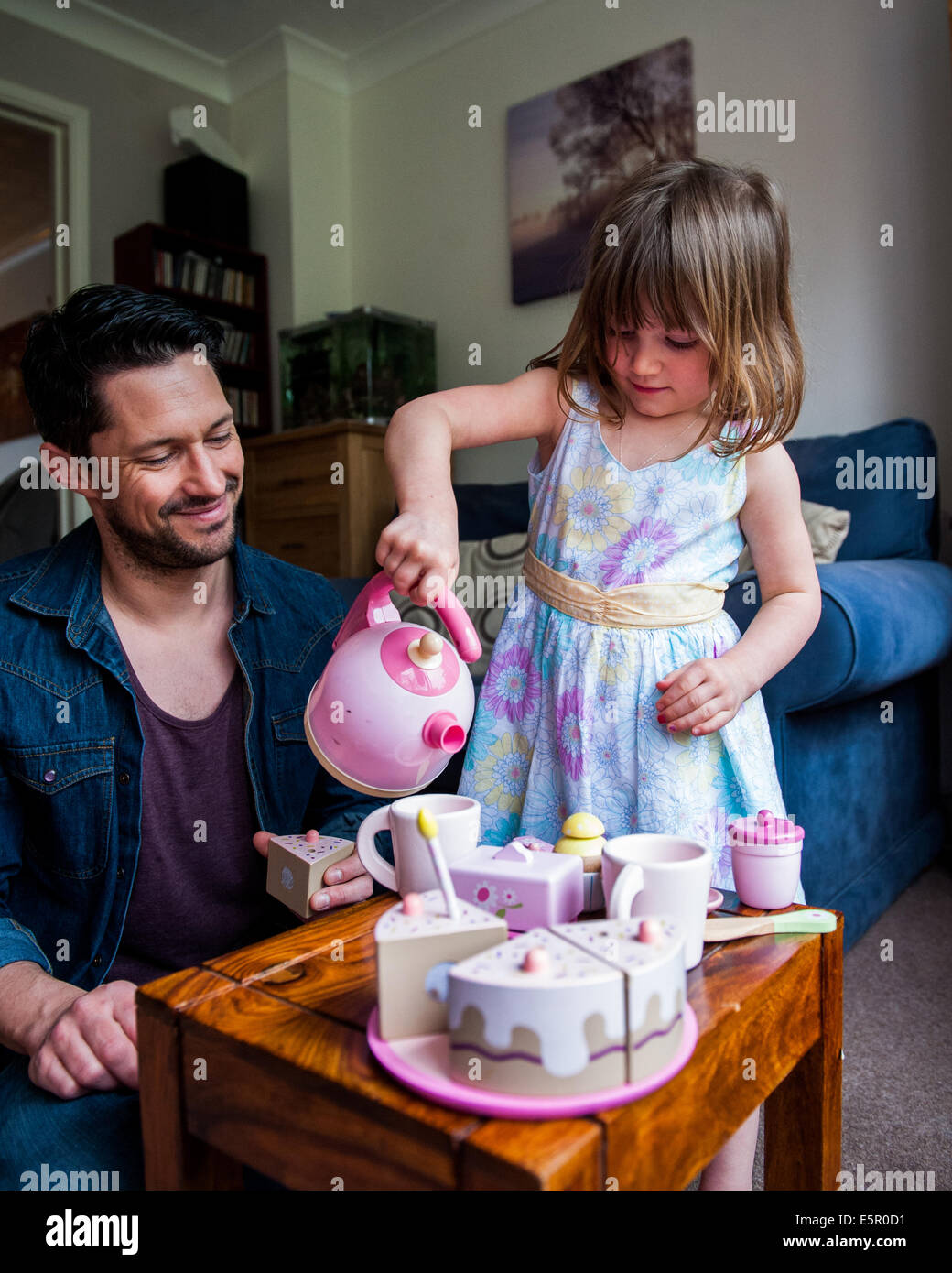 Vater mit Tochter 8 9 10 spielen Tee-sets Stockfoto