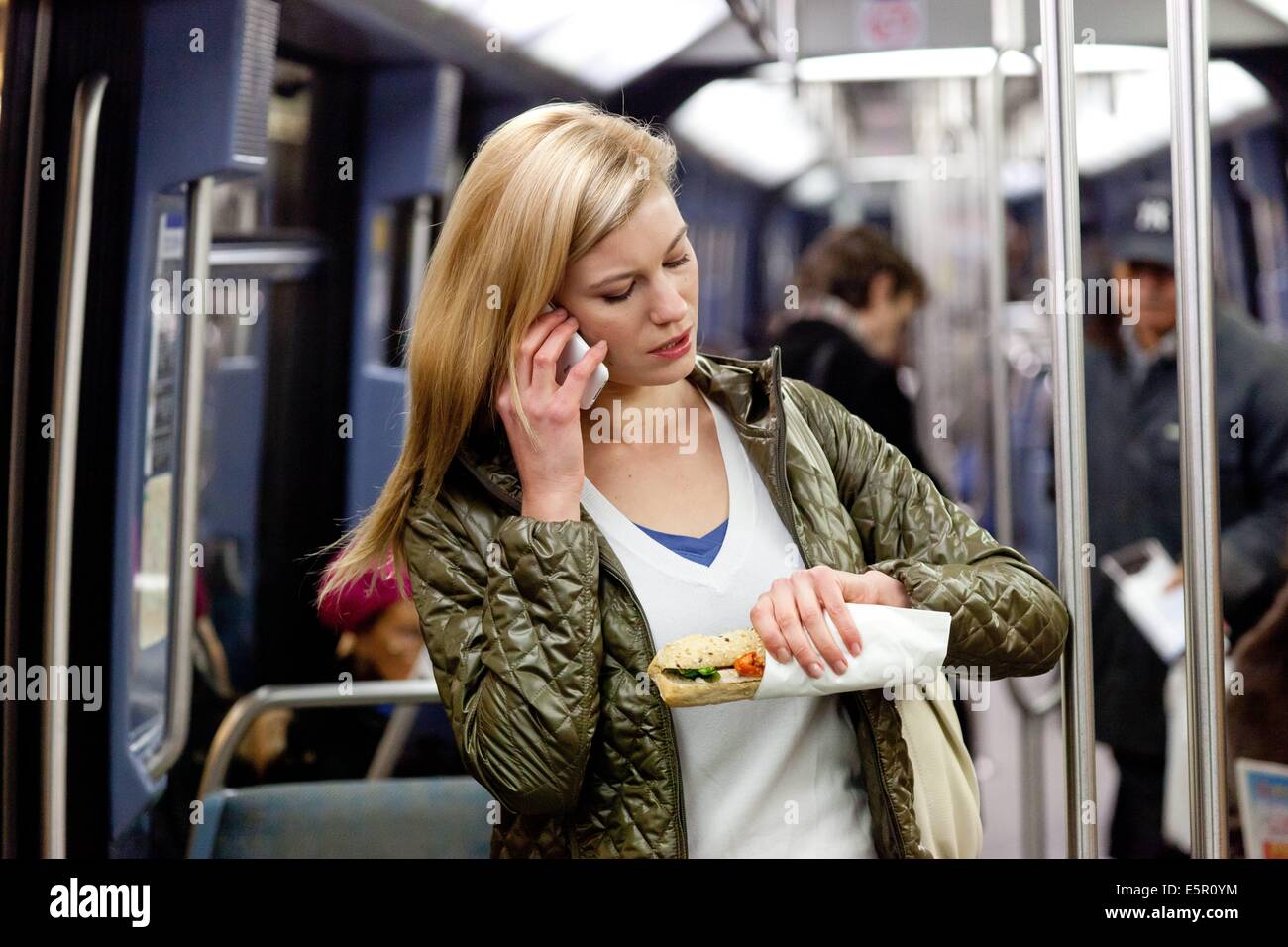 Frau in der u-Bahn ein Sandwich zu essen. Stockfoto