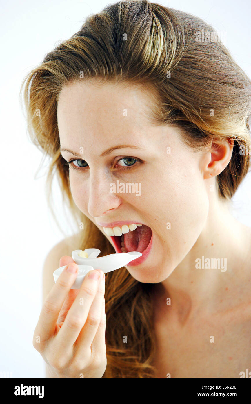 Zähne Bleichen: Frau Anwendung einen Schaum mit Bleaching Wirkstoffen in eine Elektrolumineszenz GAP-Schiene. Stockfoto