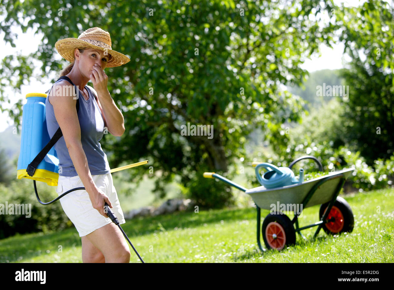 Frau Spritzen Unkrautvernichtungsmittel von Pestiziden im Garten. Stockfoto