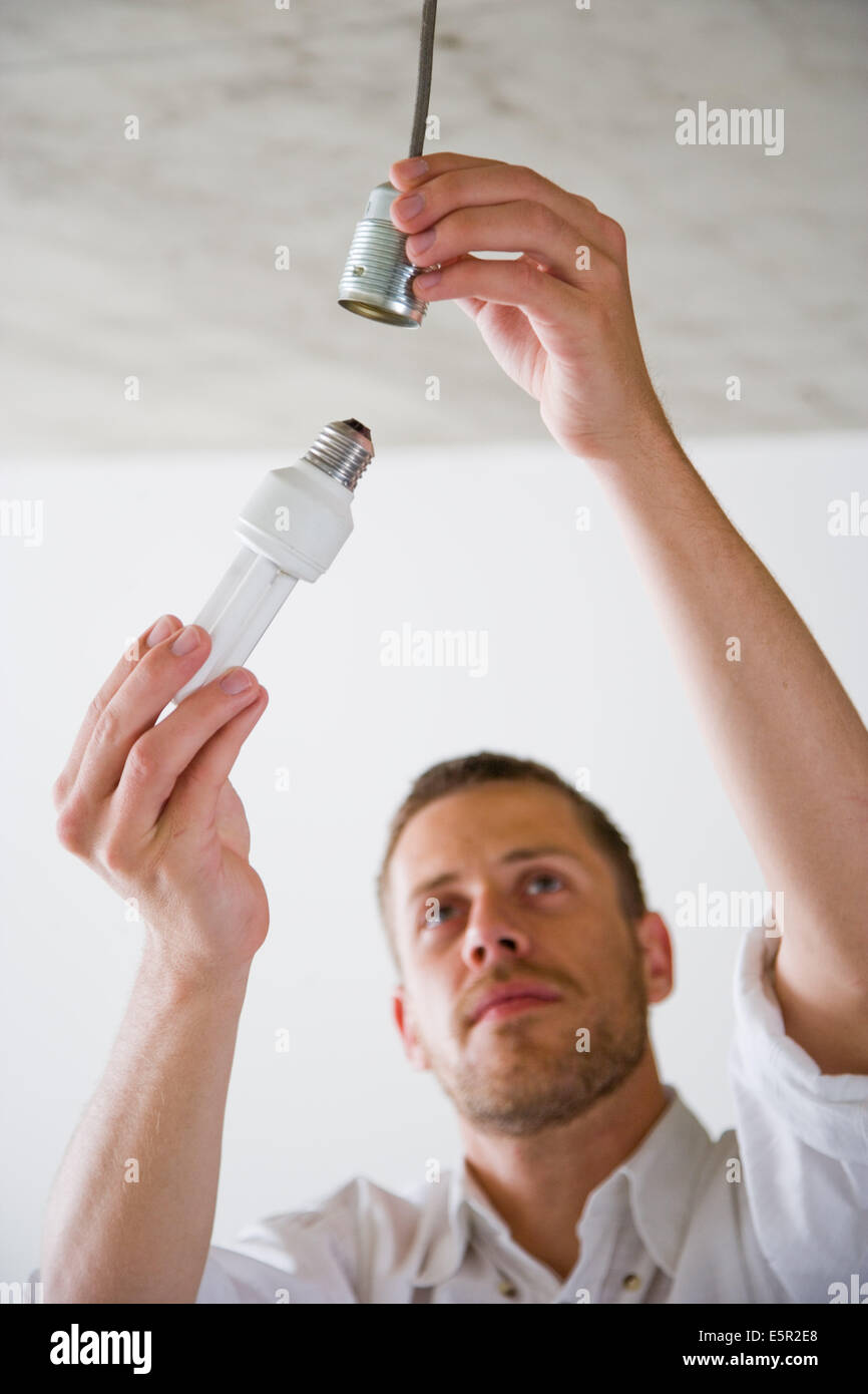 Mann wechseln einer Glühbirne. Stockfoto