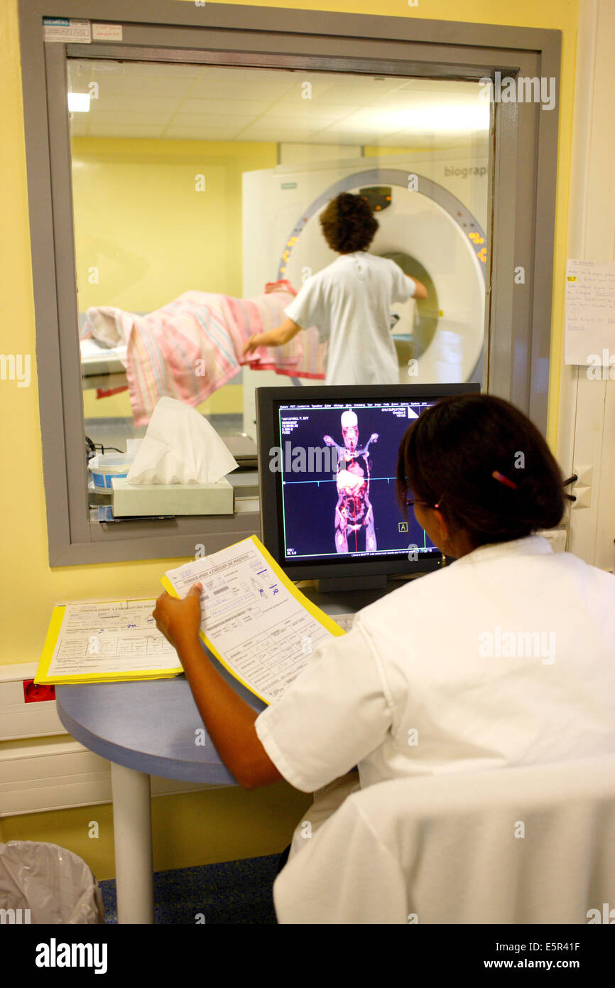 Medizinische Techniker überwacht einen Patienten einen Positronen-Emissions-Tomographie (PET)-Scan am Bildschirm "Control". Stockfoto