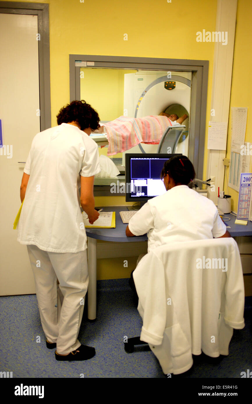 Medizinische Techniker überwachen einen Patienten einen Positronen-Emissions-Tomographie (PET)-Scan am Bildschirm "Control". Stockfoto