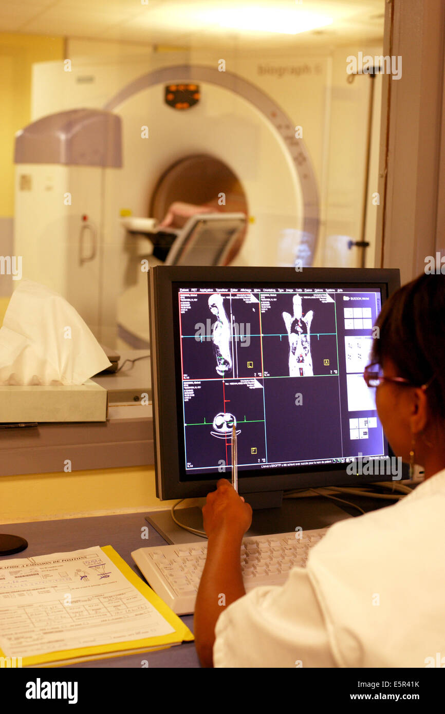 Medizinische Techniker überwacht einen Patienten einen Positronen-Emissions-Tomographie (PET)-Scan am Bildschirm "Control". Stockfoto