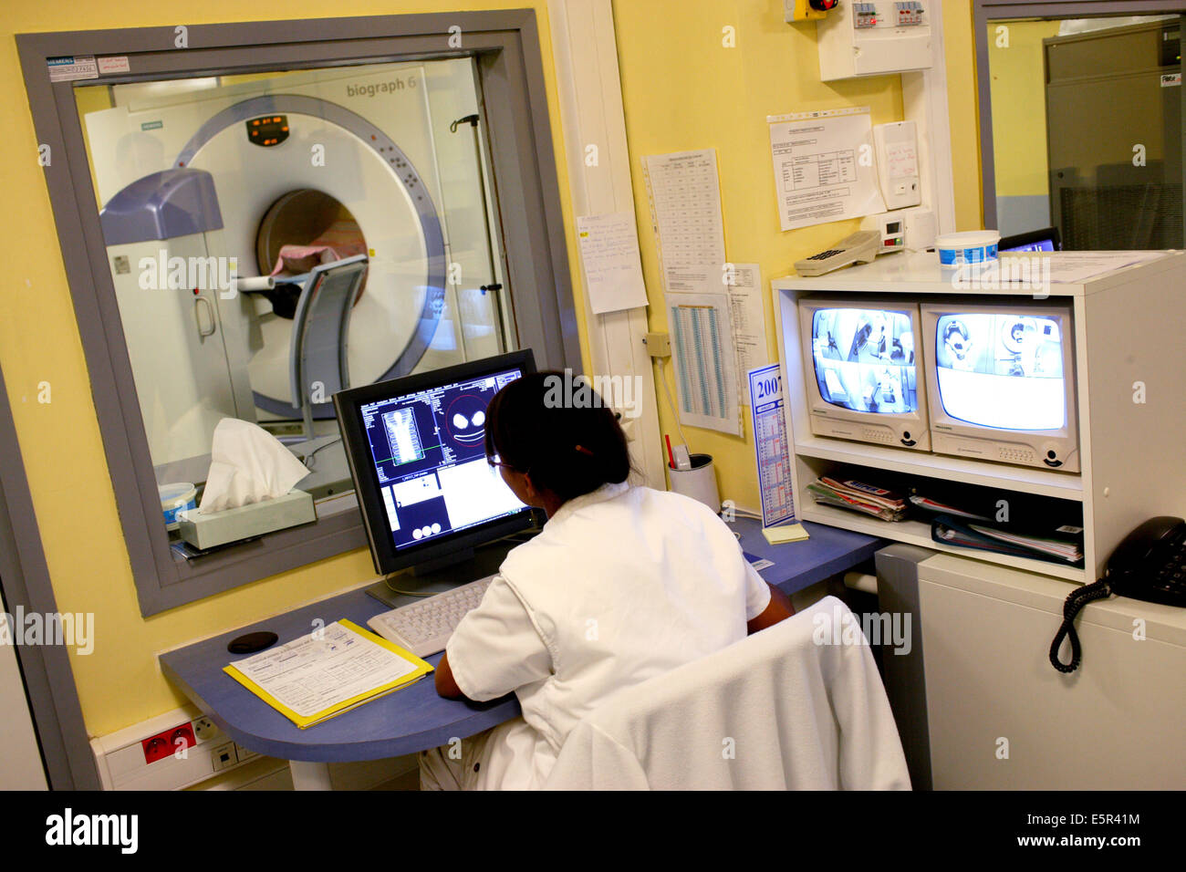 Medizinische Techniker überwacht einen Patienten einen Positronen-Emissions-Tomographie (PET)-Scan am Bildschirm "Control". Stockfoto