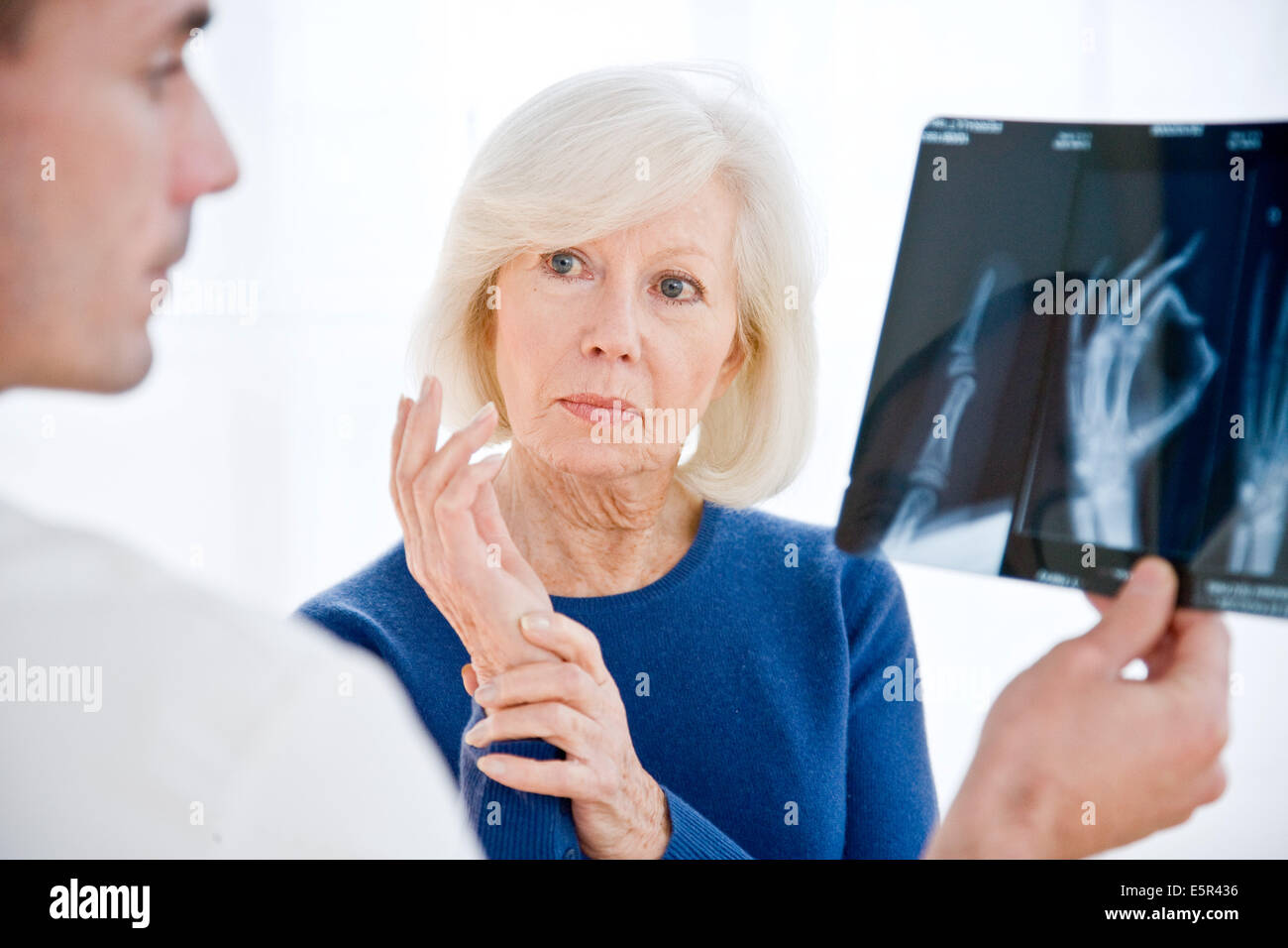 Arzt, die Hand Röntgen mit einem Patienten zu diskutieren. Stockfoto