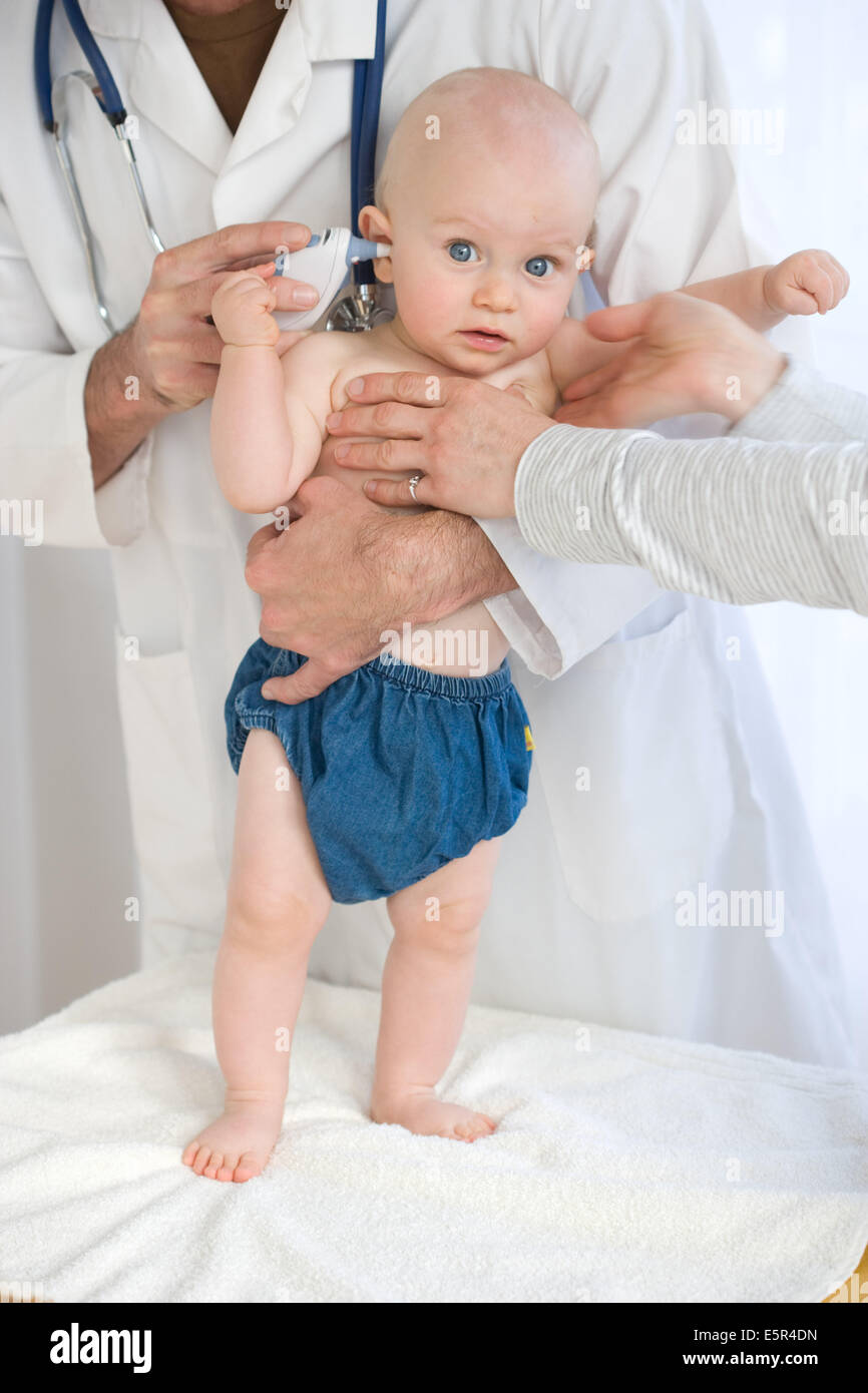 Überprüfen die Temperatur ein 9 Monate altes Baby mit Ohr-Thermometer. Stockfoto