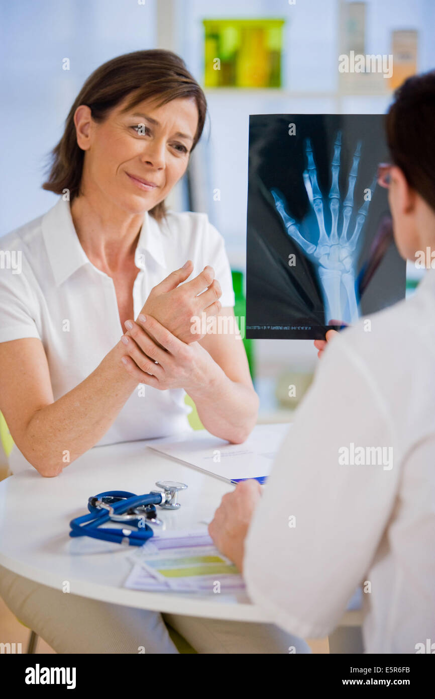 Arzt, die Hand Röntgen mit einem Patienten zu diskutieren. Stockfoto