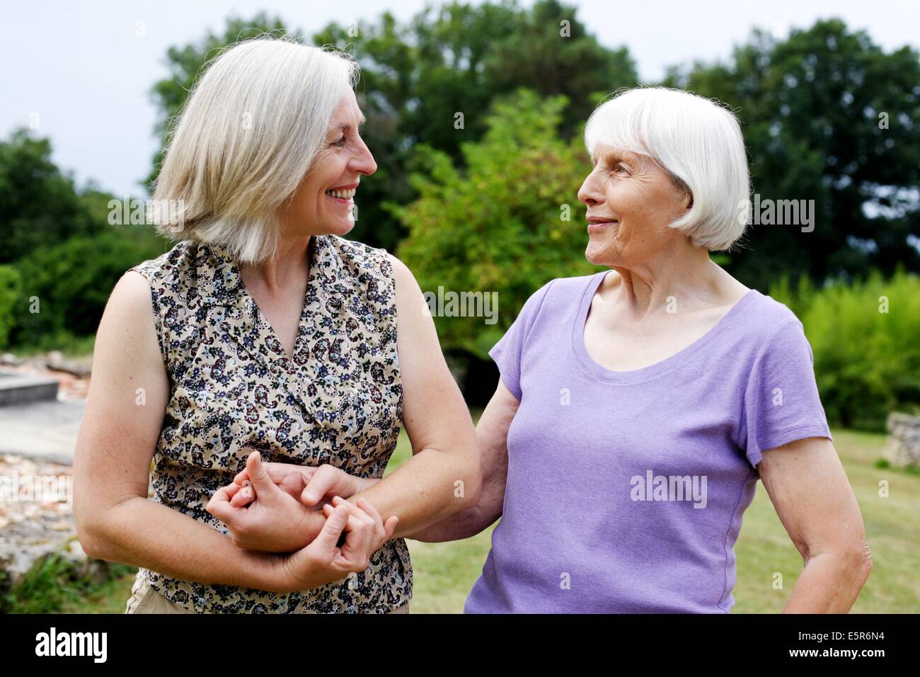 80 Jahre alte Frau mit ihrer Tochter spazieren gehen. Stockfoto