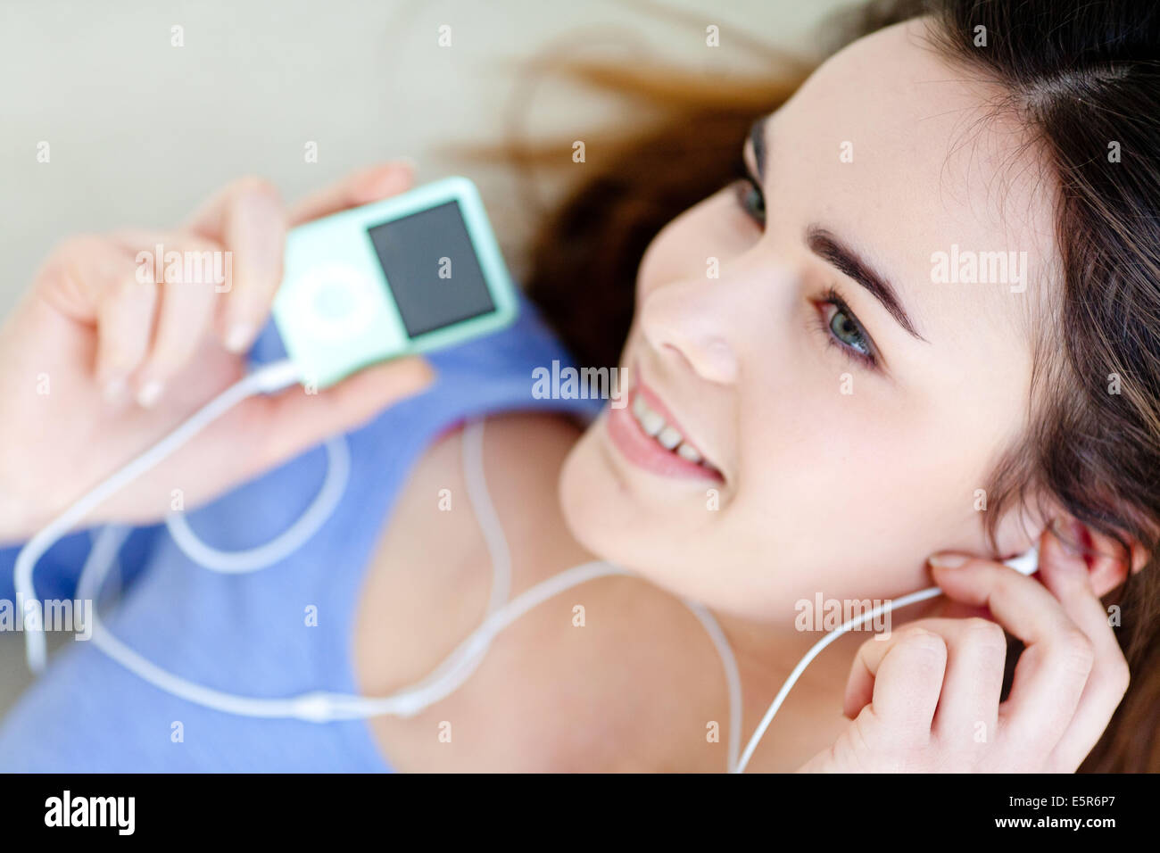 Frau Musik auf einen Ipod MP3-Player anhören. Stockfoto