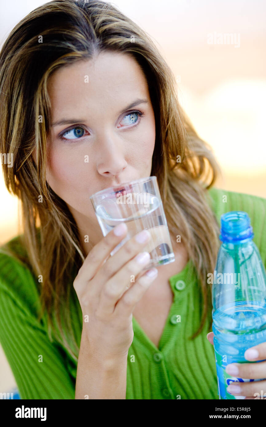 Frau trinkt ein Glas Mineralwasser. Stockfoto