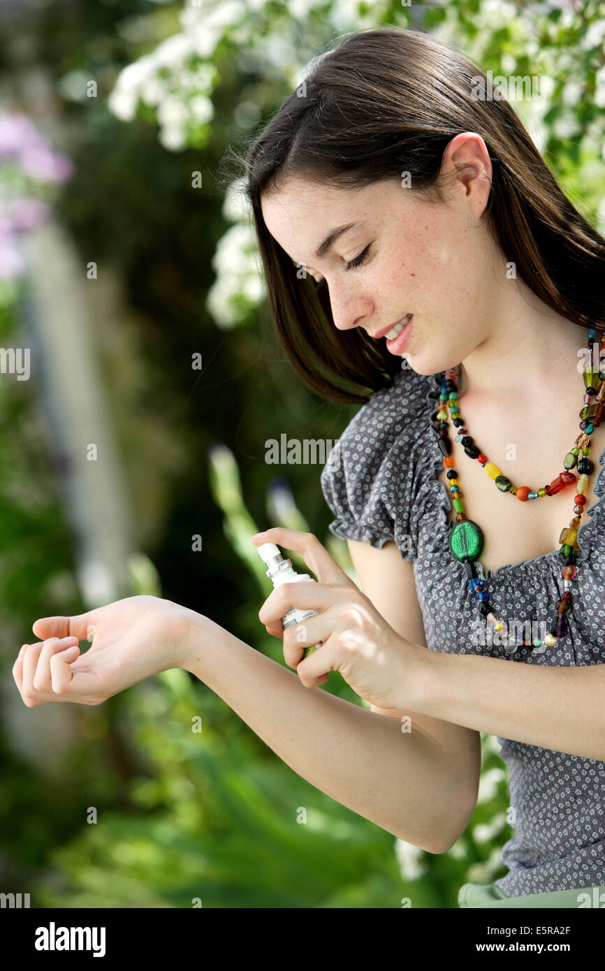 Frau mit einem Spray gegen Ankuppeln und Insektenstichen. Stockfoto