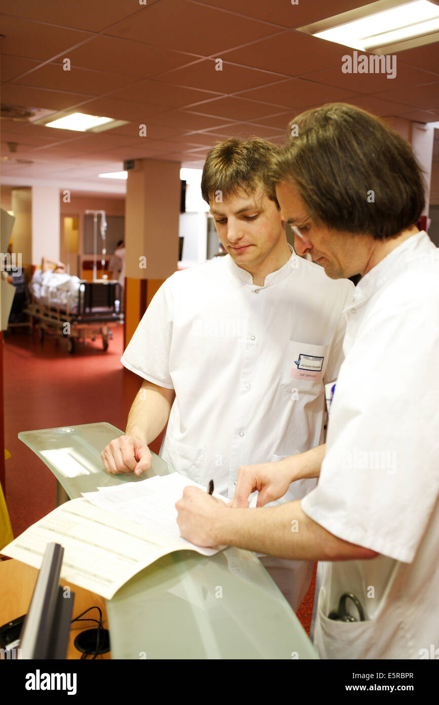 Arzt Signieren von Dokumenten gegeben durch eine Krankenschwester, Notaufnahme, Limoges Krankenhaus, Frankreich. Stockfoto