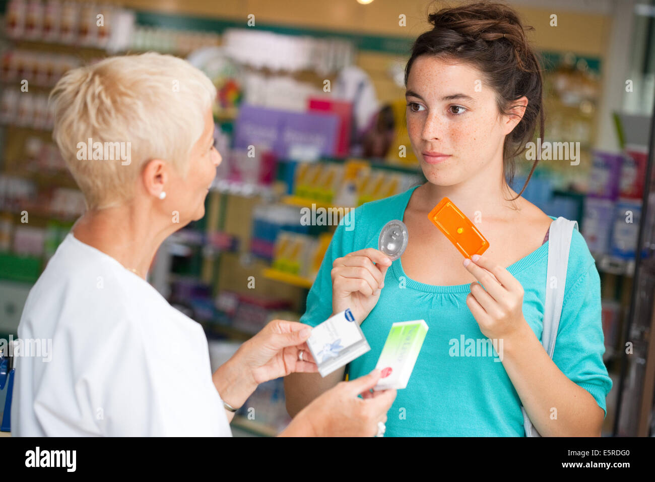 Apotheker erklärt eine junge Frau mit der empfängnisverhütenden Pille (Norvelo Pille danach und Generika). Stockfoto