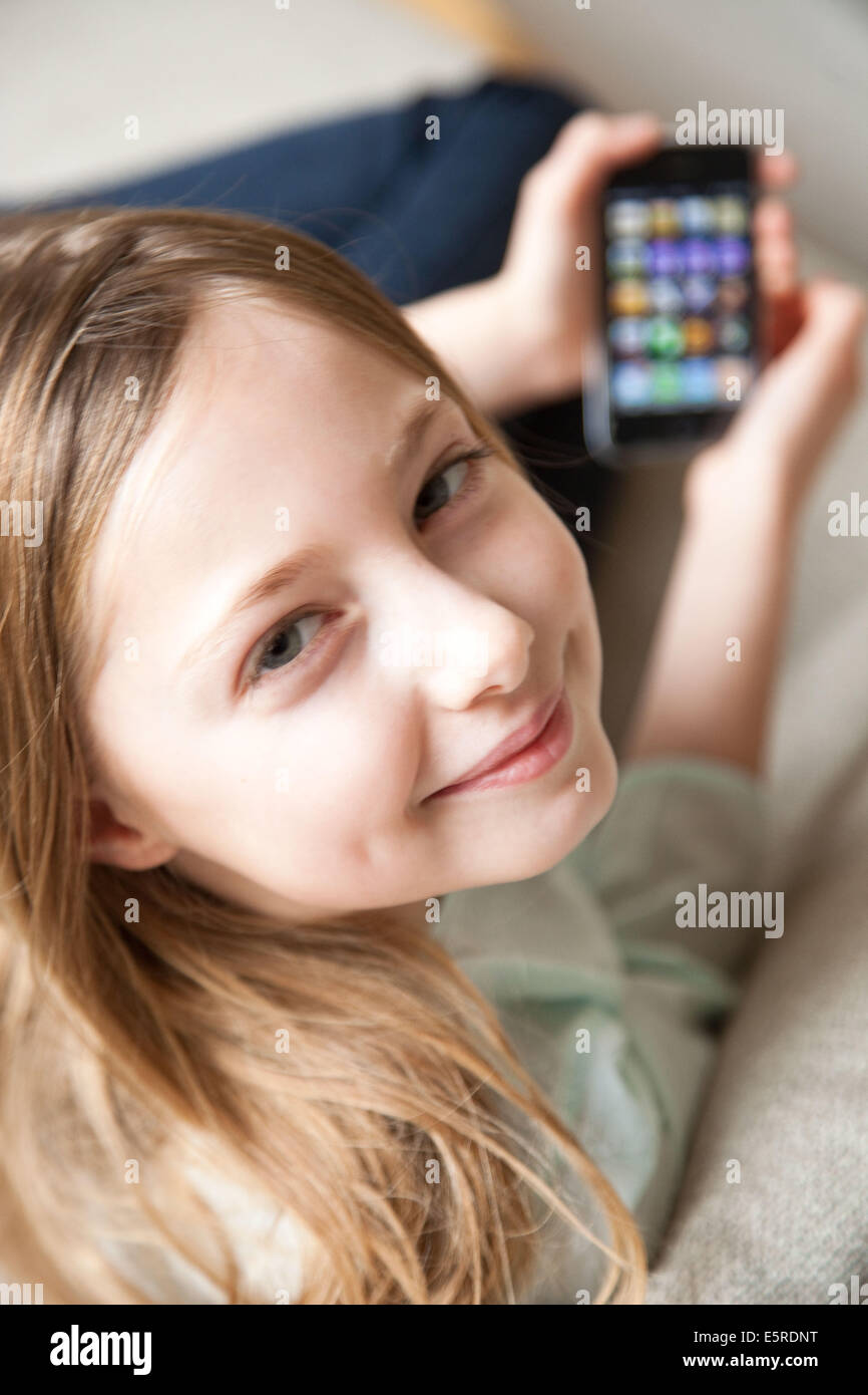 9 Jahre altes Mädchen spielen mit Iphone®. Stockfoto