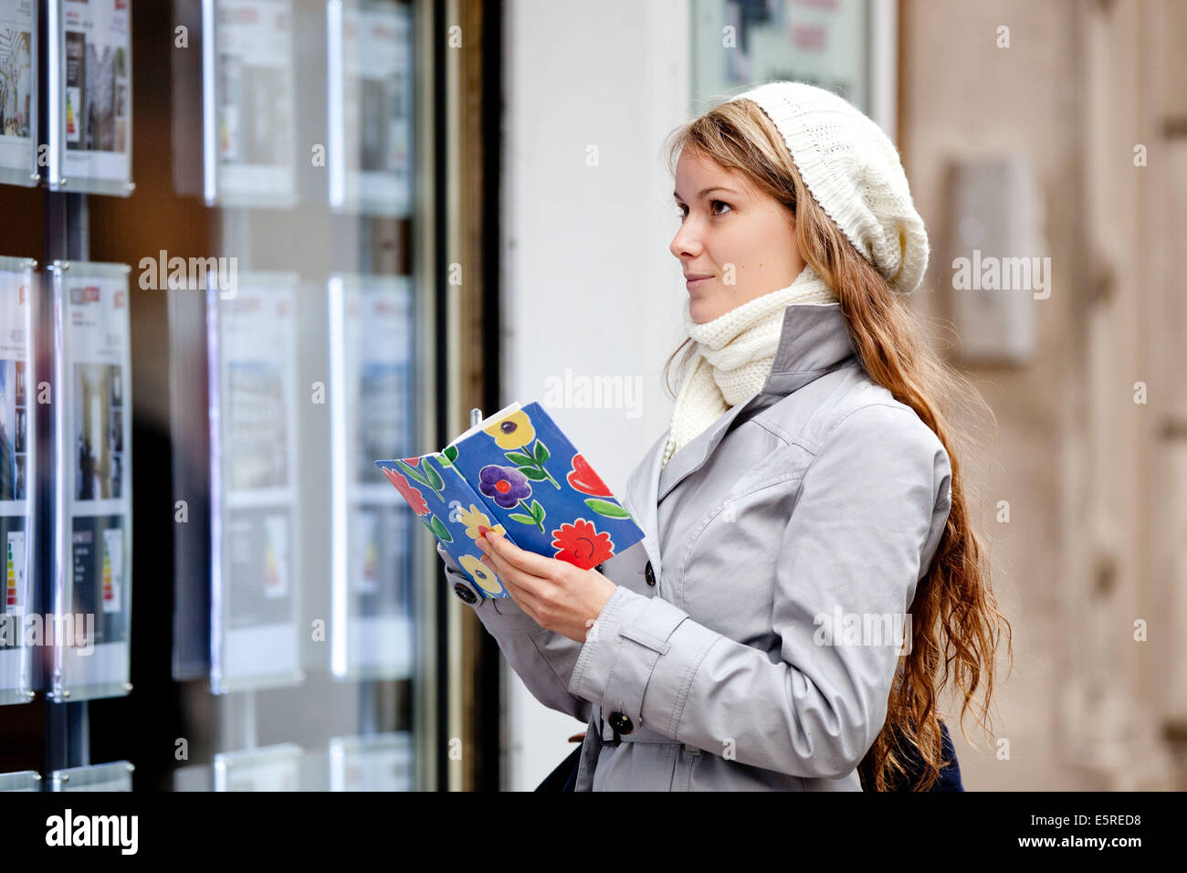 Frau sucht anzeigen in einer Immobilienagentur. Stockfoto