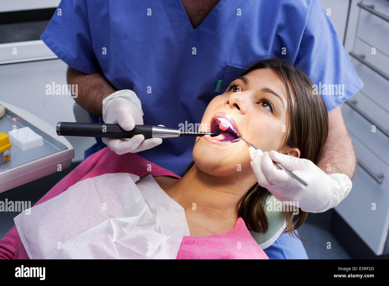Zahnarzt mit UV-Licht eine lichtempfindliche Amalgam (Füllung) festlegen. Stockfoto