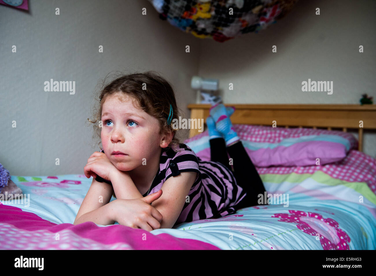 Mädchen schauen traurig in Schlafzimmer Stockfoto
