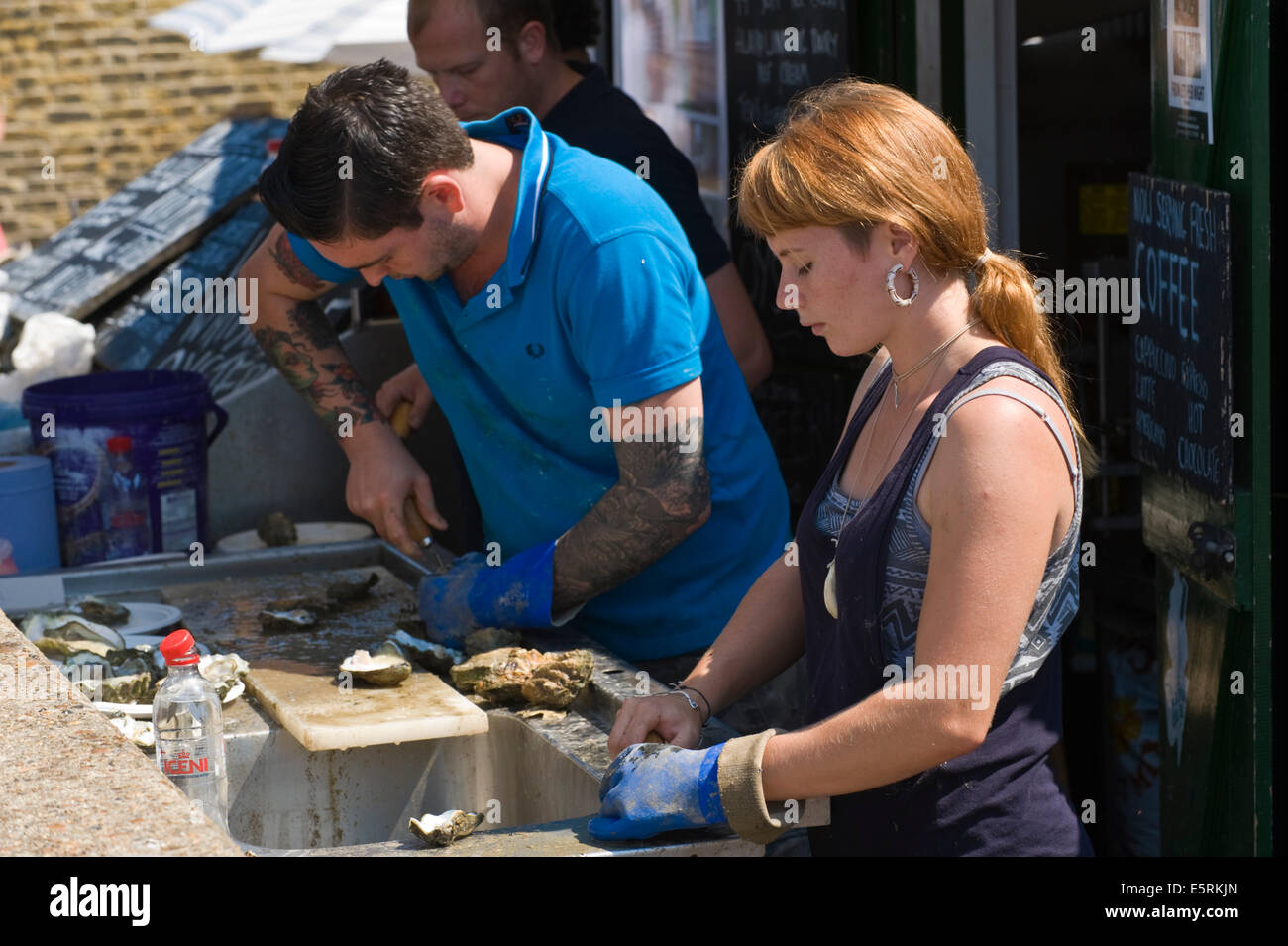 Dem Entfernen Austern am Strand Openair Seafood Café in Whitstable Oyster Festival Kent England UK Stockfoto