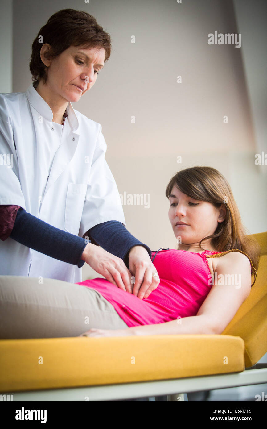 Arzt untersucht den Bauch einer Patientin durch Abtasten. Stockfoto