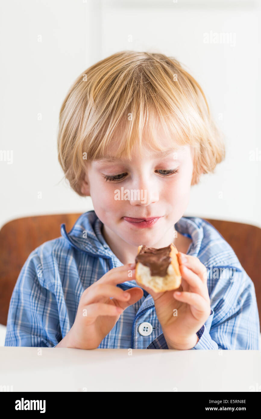 Junge Schokolade auf Brot zu essen. Stockfoto