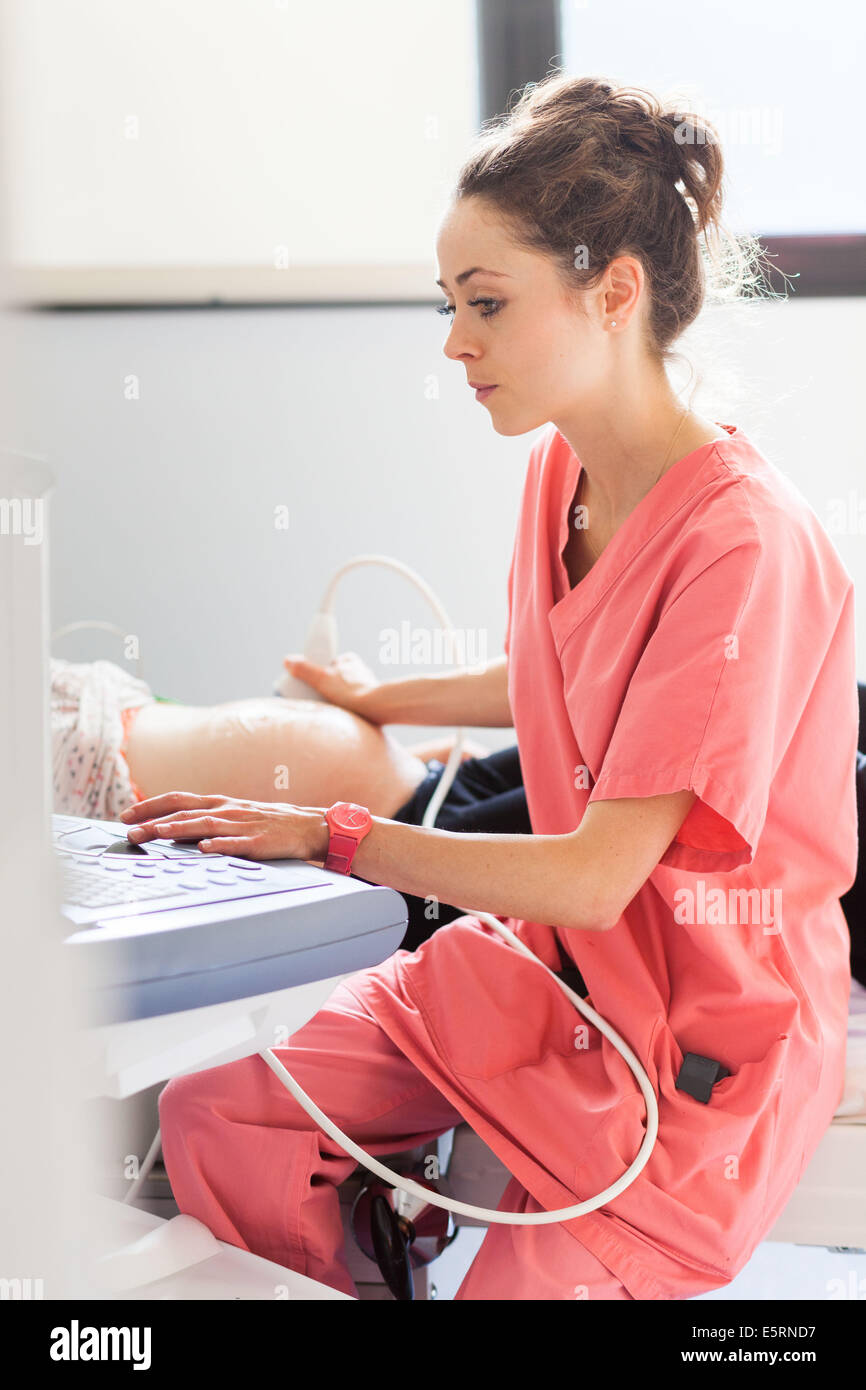 8 Monate schwangere Frau durchmachenden fötale Ultraschalluntersuchung von Gynäkologen durchgeführt. Abteilung für Geburtshilfe und Gynäkologie Stockfoto