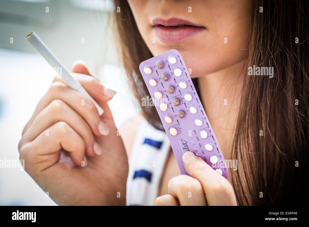 Frau mit orale Kontrazeption Pillen und Zigarette. Stockfoto