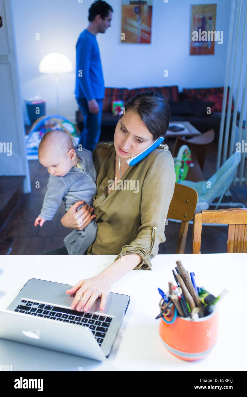 Mutter am Telefon und ihr 5 Monate altes Baby Boy. Stockfoto