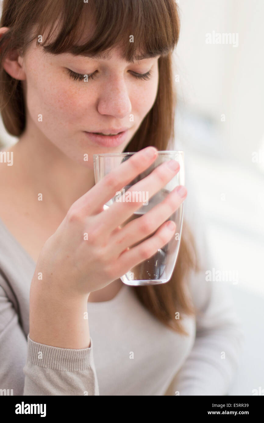 Frau trinkt ein Glas Wasser. Stockfoto