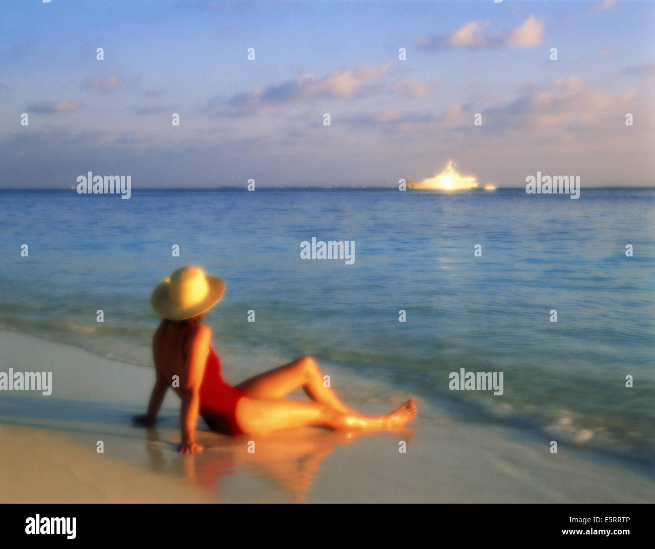 Frau sitzt am Strand mit Blick auf das Meer (soft-Fokus) Stockfoto