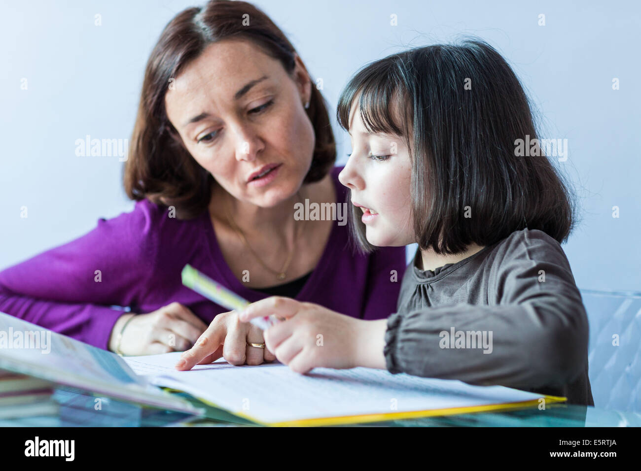 9-Year-Old Girl ihre Hausaufgaben bei der Mutter. Stockfoto