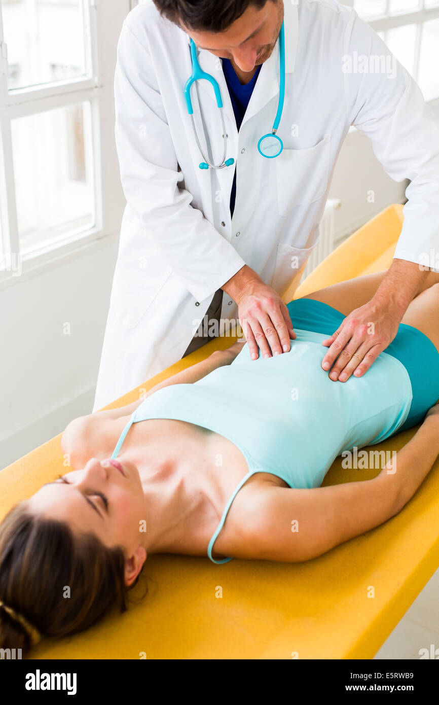 Arzt untersucht den Bauch einer Patientin durch Abtasten. Stockfoto