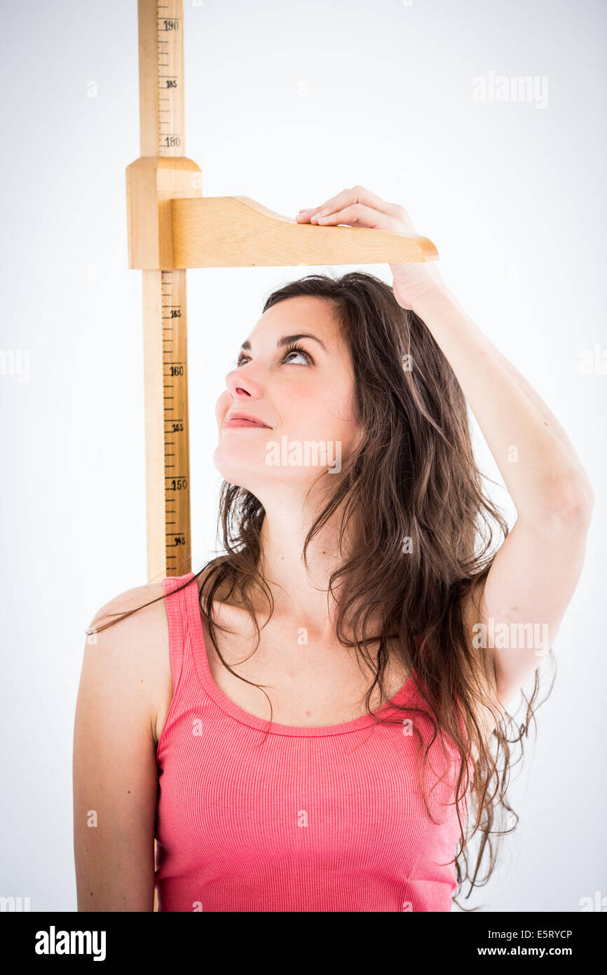 Frau unter Höhe Messgerät. Stockfoto