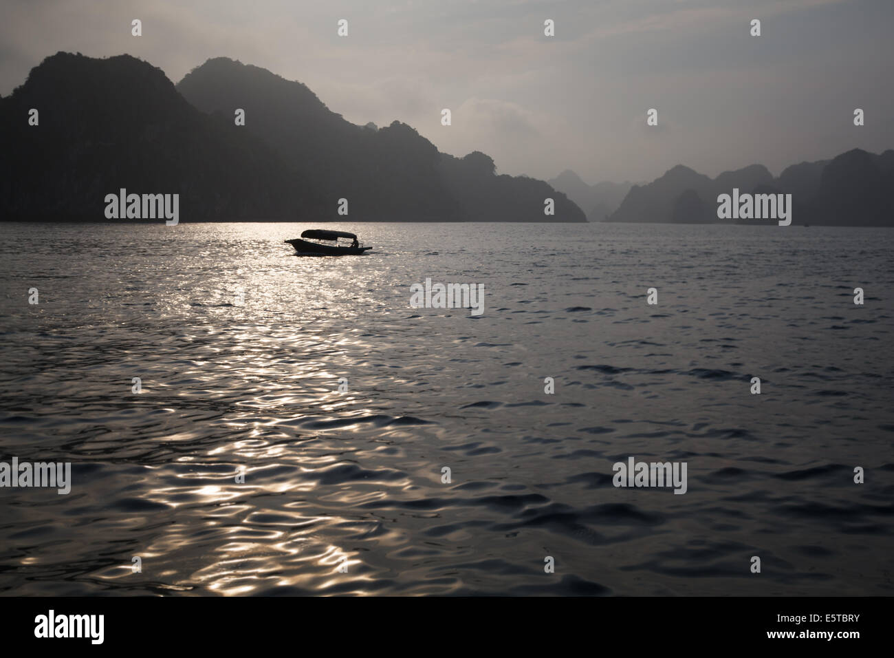 Ein Blick auf eine Person in ihrer kleinen Holzboot in Lan-Ha-Bucht, in der Nähe von Cat Ba Island, Vietnam Stockfoto