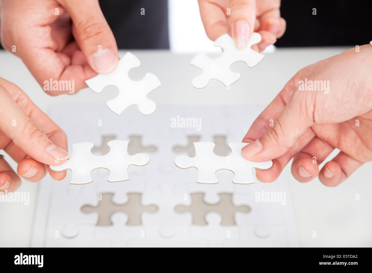 Business-Team hält Jigsaw Puzzle auf dem Schreibtisch Stockfoto