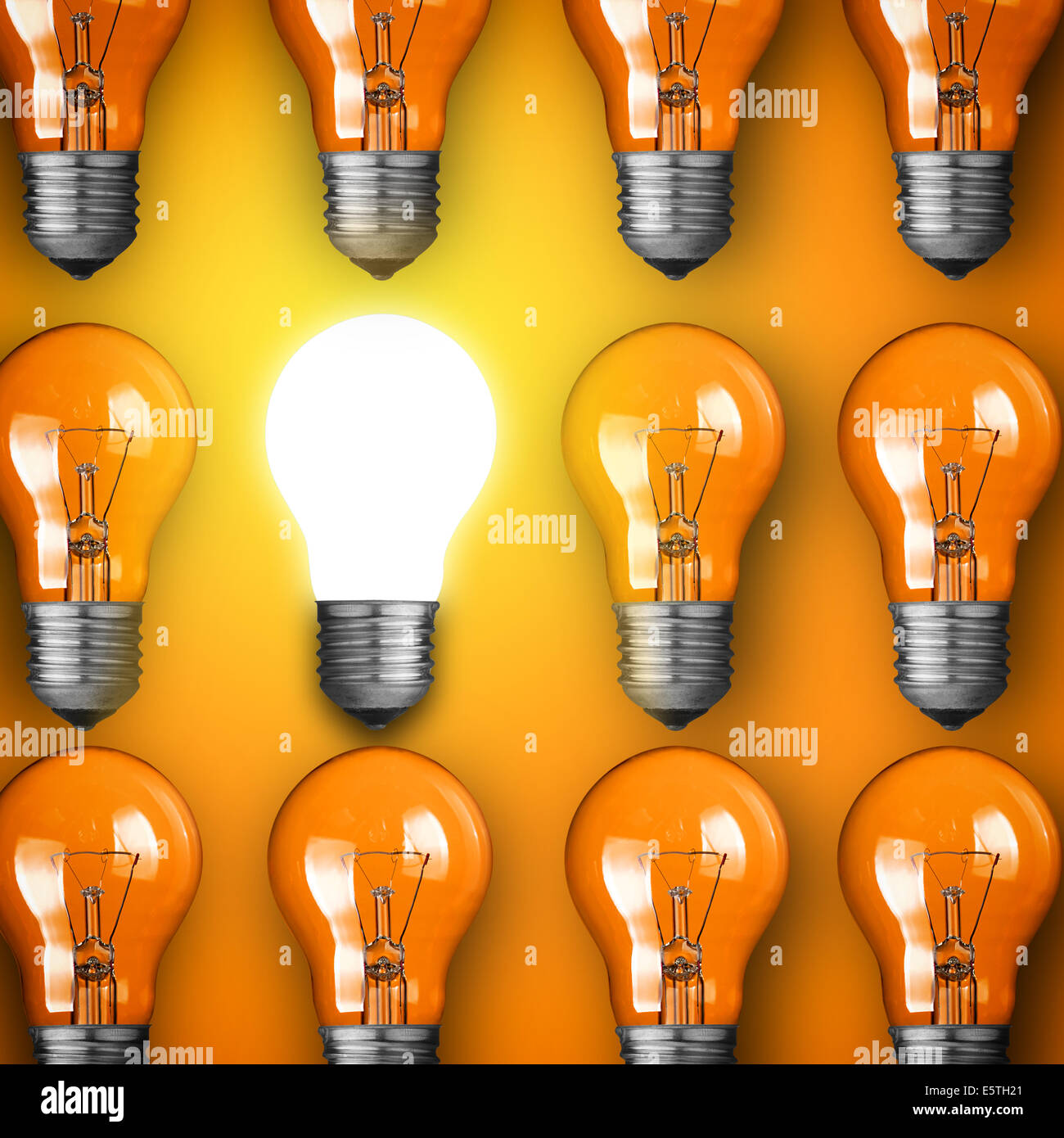 Konzept für große Idee. Leuchtende Glühbirne auf orangem Hintergrund Stockfoto