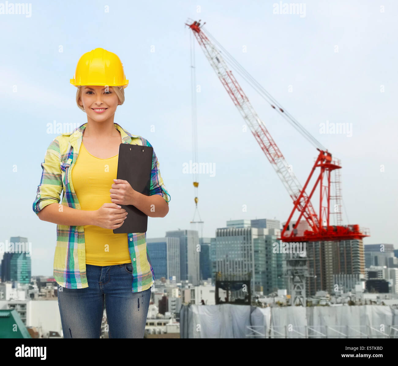 lächelnde Frau in Helm mit Zwischenablage Stockfoto