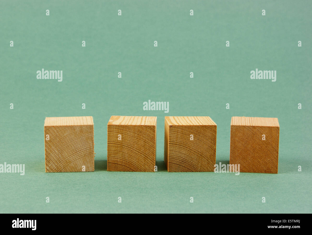 geometrische Holzwürfel auf grünem Hintergrund Stockfoto