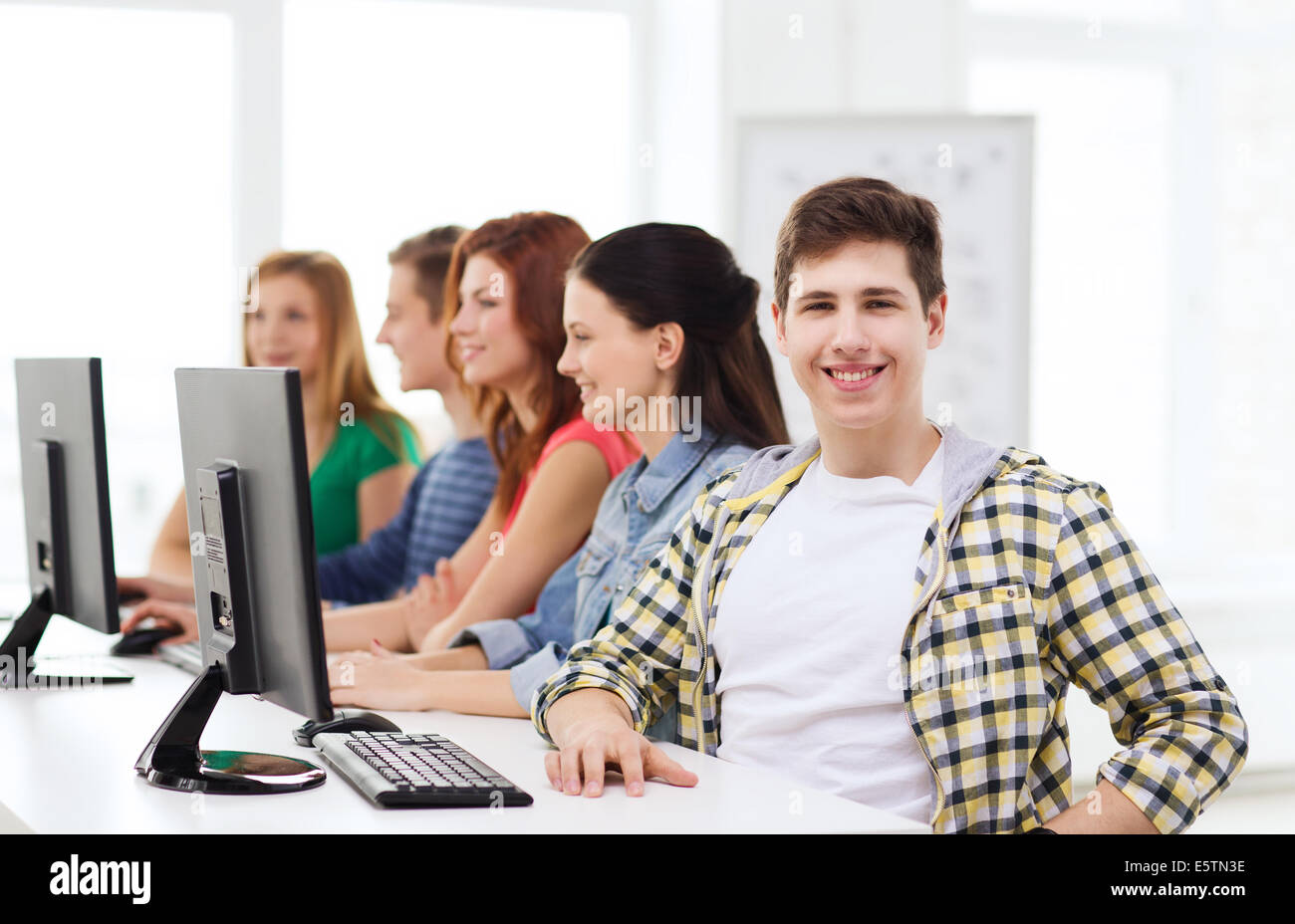 männliche Schüler mit Klassenkameraden in Computer-Klasse Stockfoto