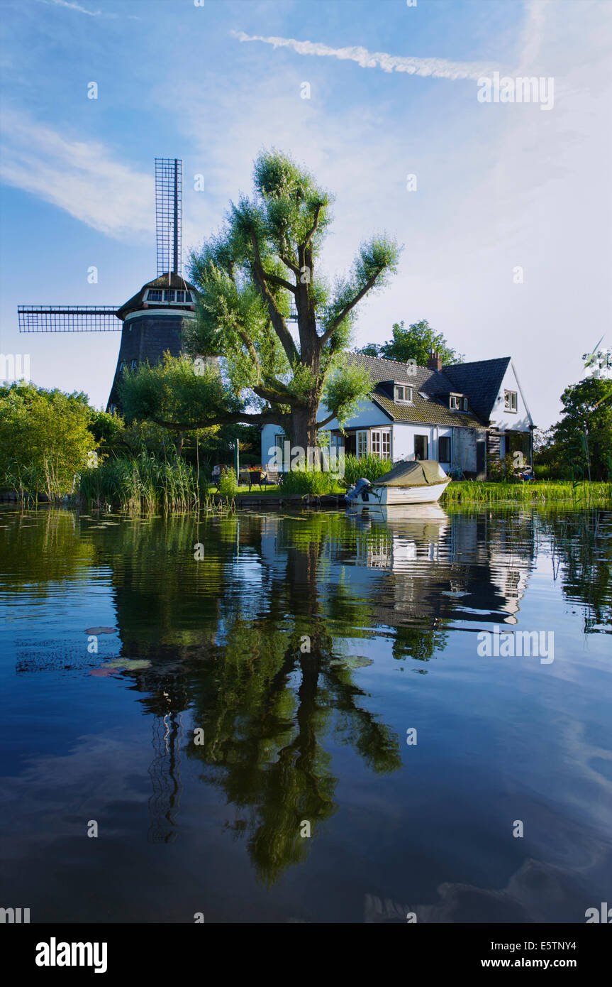 Schönes Haus mit einer Windmühle am Spiegelplas oder Mirror Lake in Nord-Holland, Niederlande Stockfoto