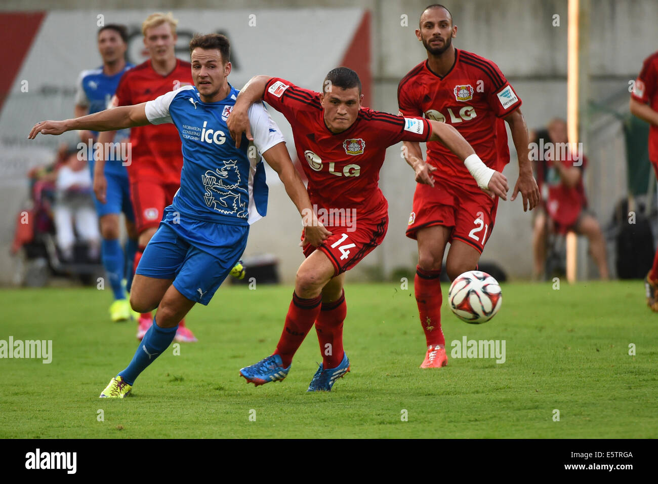 Wuppertaler Davide Leikauf (L) und Leverkusens Kyriakos Papadopoulos (C) in Aktion während der Fußball-Testspiel zwischen dem Wuppertaler SV und Bayer Leverkusen im Stadion am Zoo in Wuppertal, Deutschland, 5. August 2014. Foto: Matthias Balk/dpa Stockfoto