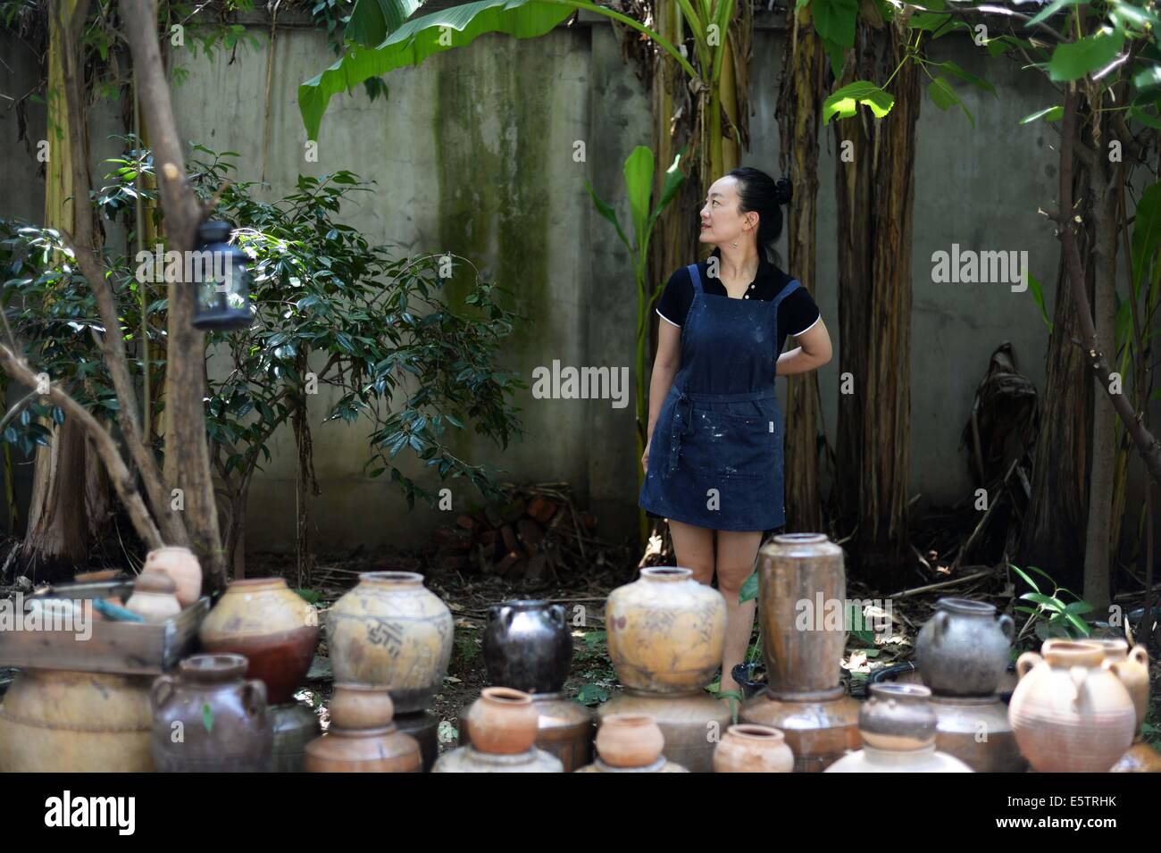 (140806)--Peking, 6. August 2014 (Xinhua)--Zhang Lingyun posiert für Fotos in einem Hof in ihrem Haus in Jingdezhen, Osten Chinas Jiangxi Provinz, 17. Juli 2014.    Zhang Lingyun ist 40. Seit 20 Jahren kam der keramische-Künstlerin, Jingdezhen, Chinas "Porzellan-Hauptstadt".    Zhangs Geschichte mit Keramik hatte einen zufälligen, romantischen Start: sie wusste kaum etwas über Keramik, bevor sie auf den Namen "Jingdezhen Keramik Institut (JCI)" kam bei der Bewerbung für das College. "Keramik Klang interessant, so dass ich die Anwendung für JCI eingereicht." Die Laune der Impuls machte großen Unterschied in Zhangs li Stockfoto