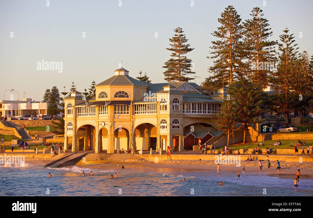 Schwimmer, entspannen und Baden am Sonnenuntergang vor der legendären alten Pavillon am Cottesloe Beach in Perth, Western Australia. Stockfoto