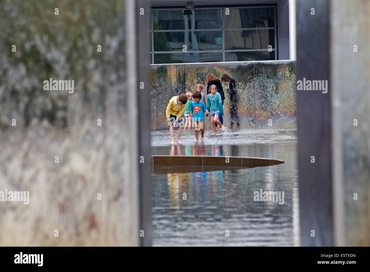 genießen das Wasser - Kinder spielen im Wasserbrunnen im Millenium Square, Harbourside, Bristol im Mai Stockfoto