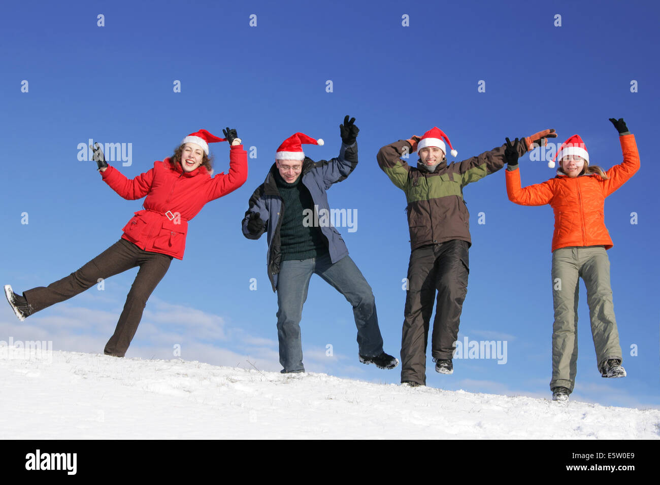 Freunde mit Santa Hüte tanzen auf Flanke des Hügels Stockfoto