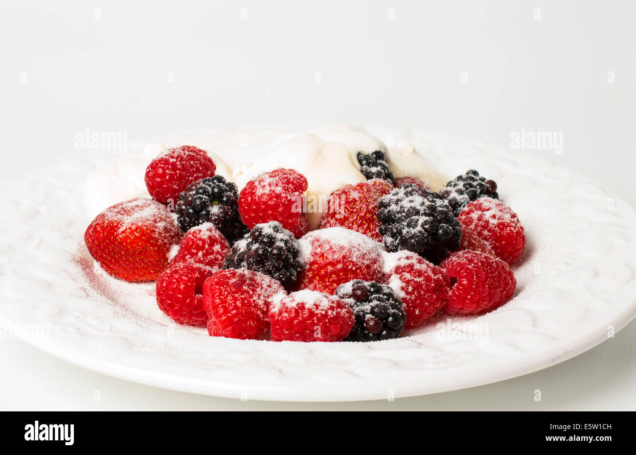 Frische Erdbeeren und Brombeeren mit Sahne und eine Prise Sommer Stockfoto